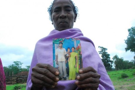 Click on image to see full-sized version Villager shows photo of murdered loved one.